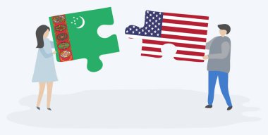 Türkmen ve Amerikan bayrakları ile iki bulmaca parçaları tutan çift. Türkmenistan ve Amerika Birleşik Devletleri ulusal sembolleri birlikte.