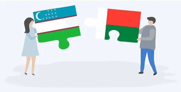ウズベキスタンとマダガスカルの旗を持つ2つのパズルピースを保持しているカップル ウズベキスタンとマダガスカルの国のシンボル — ストックベクタ