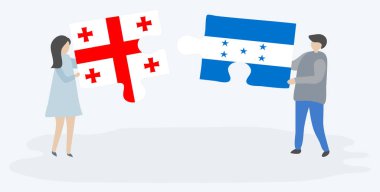 Gürcü ve Honduras bayraklarıile iki bulmaca parçası tutan çift. Gürcistan ve Honduras ulusal sembolleri birlikte.