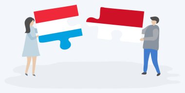 Lüksemburg ve Monegasque bayrakları ile iki bulmaca parçaları tutan çift. Lüksemburg ve Monako ulusal sembolleri birlikte.