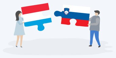 Lüksemburg ve Sloven bayrakları ile iki bulmaca parçaları tutan çift. Lüksemburg ve Slovenya ulusal sembolleri birlikte.