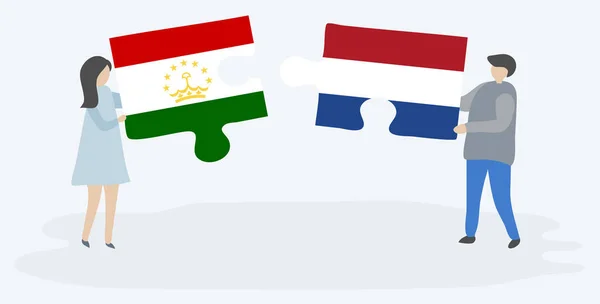 タジキスタンとオランダの旗を持つ2つのパズルピースを保持しているカップル タジキスタンとオランダの国のシンボル — ストックベクタ