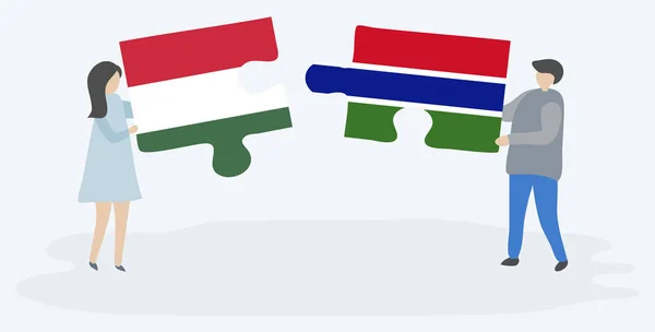 一对夫妇拿着两个拼图片与匈牙利和冈比亚国旗 匈牙利和冈比亚国家符号在一起 — 图库矢量图片
