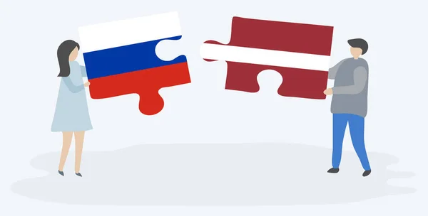 Para Trzyma Dwa Kawałki Puzzle Rosyjskimi Łotewskich Flag Symbole Narodowe — Wektor stockowy