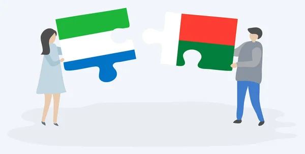 一对夫妇拿着两块拼图 上面挂着塞拉利昂和马达加斯加国旗 塞拉利昂和马达加斯加国家符号在一起 — 图库矢量图片