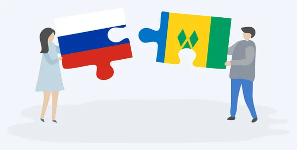 ロシアとヴィンセントの旗を持つ2つのパズルのピースを保持しているカップル ロシアとセントビンセントとグレナディーン諸島の国のシンボル — ストックベクタ