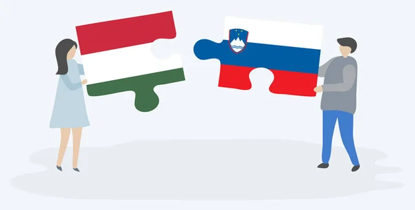 一对夫妇拿着两个拼图 上面挂着匈牙利和斯洛文尼亚国旗 匈牙利和斯洛文尼亚国家符号在一起 — 图库矢量图片
