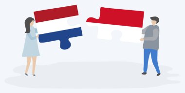 Hollanda ve Monegasque bayrakları ile iki bulmaca parçaları tutan çift. Hollanda ve Monako ulusal sembolleri birlikte.