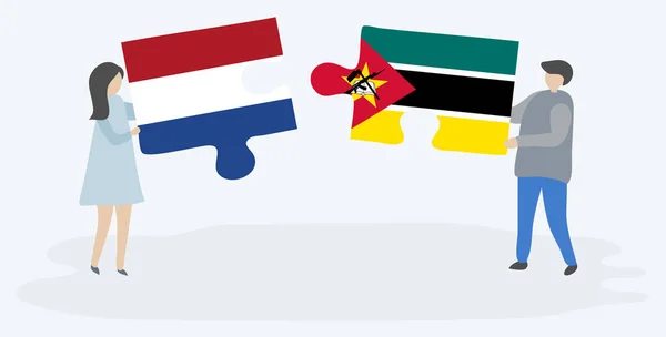 Para Trzymania Dwóch Puzzli Holenderskimi Mozambicki Flagi Symbole Narodowe Holandii — Wektor stockowy