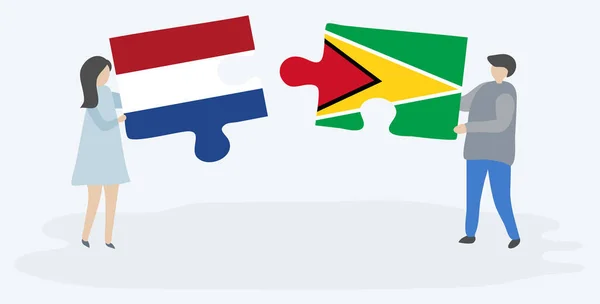 一对夫妇拿着两块拼图 上面挂着荷兰和圭亚那国旗 荷兰和圭亚那国家符号在一起 — 图库矢量图片