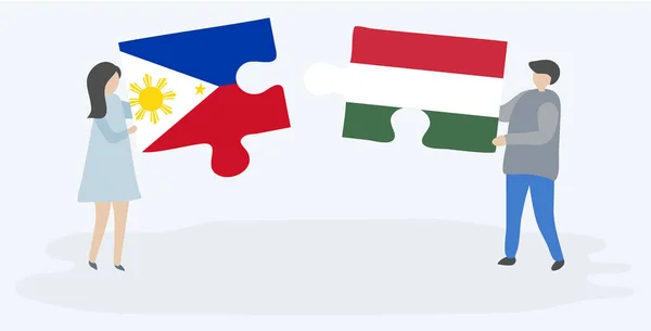 一对夫妇拿着两个拼图 上面挂着菲律宾和匈牙利国旗 菲律宾和匈牙利国家符号在一起 — 图库矢量图片
