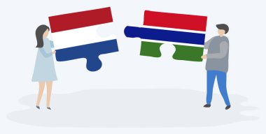 Hollanda ve Gambiya bayrakları ile iki bulmaca parçaları tutan çift. Hollanda ve Gambiya ulusal sembolleri birlikte.
