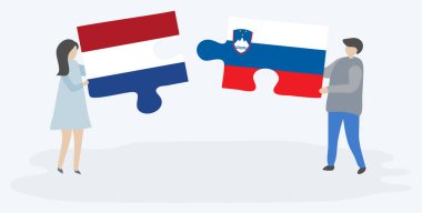 Hollanda ve Sloven bayrakları ile iki bulmaca parçaları tutan çift. Hollanda ve Slovenya ulusal sembolleri birlikte.