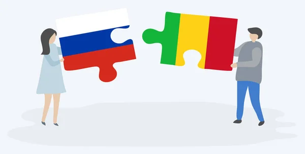 ロシアとマリの旗を持つ2つのパズルのピースを保持しているカップル ロシアとマリの国のシンボル — ストックベクタ