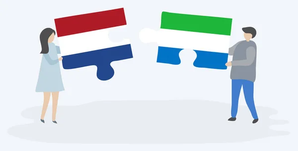一对夫妇拿着两块拼图 上面挂着荷兰和塞拉利昂国旗 荷兰和塞拉利昂国家符号在一起 — 图库矢量图片