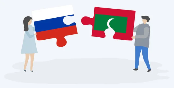 ロシアとモルディブの旗を持つ2つのパズルのピースを保持しているカップル ロシアとモルディブのシンボル — ストックベクタ