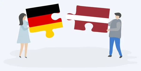Para Trzyma Dwa Kawałki Puzzli Niemieckimi Łotewskimi Flagami Symbole Narodowe — Wektor stockowy