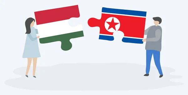 Para Trzyma Dwa Kawałki Puzzli Węgierskimi Północnokoreańskimi Flagami Symbole Narodowe — Wektor stockowy