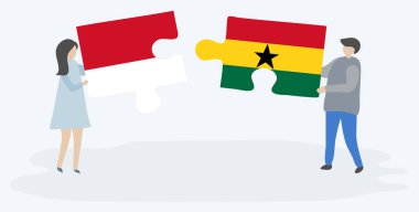 Endonezya ve Gana bayrakları ile iki bulmaca parçaları tutan çift. Endonezya ve Gana ulusal sembolleri birlikte.