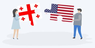 Gürcü ve Amerikan bayraklarıyla iki bulmaca tutan çift. Gürcistan ve Amerika Birleşik Devletleri ulusal sembolleri birlikte.