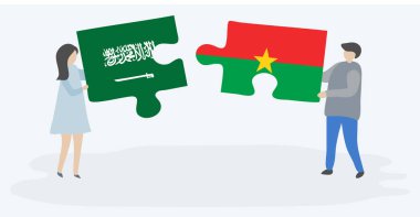 Suudi Arabistan ve Burkinabe bayrakları ile iki bulmaca parçaları tutan çift. Suudi Arabistan ve Burkina Faso ulusal sembolleri birlikte.