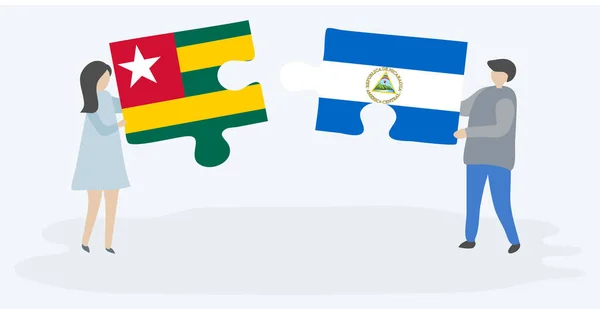Para Trzyma Dwa Kawałki Puzzli Togolese Nikaraguan Flagi Togo Nikaragua — Wektor stockowy