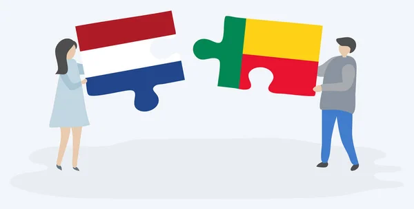 一对夫妇拿着两个拼图与荷兰和贝宁国旗 荷兰和贝宁国家符号在一起 — 图库矢量图片