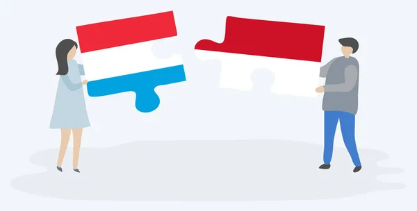 一对夫妇拿着两块拼图 上面挂着卢森堡和印度尼西亚国旗 卢森堡和印度尼西亚国家符号在一起 — 图库矢量图片