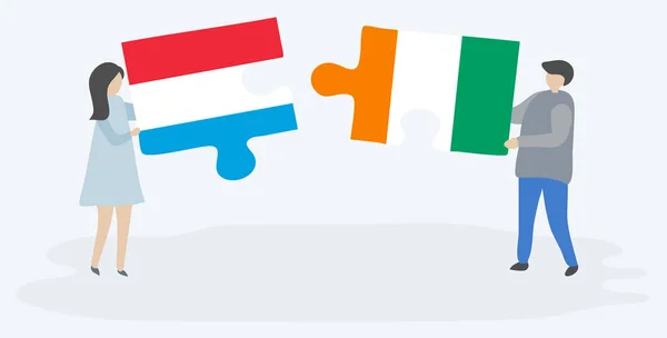 一对夫妇拿着两块拼图 上面挂着卢森堡国旗和科特迪瓦国旗 卢森堡和象牙海岸国家符号在一起 — 图库矢量图片