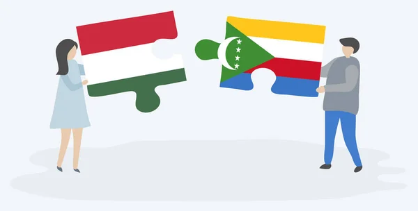 ハンガリーとコモランの旗を持つ2つのパズルピースを保持しているカップル ハンガリーとコモロの国のシンボル — ストックベクタ