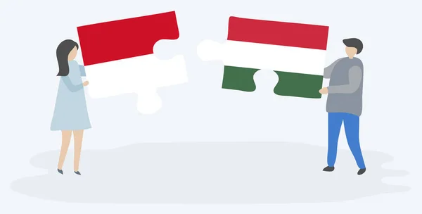 モネガスクとハンガリーの旗を持つ2つのパズルピースを保持しているカップル モナコとハンガリーのシンボル — ストックベクタ