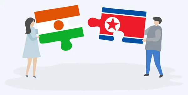 一对夫妇拿着两块拼图 上面挂着尼日尔和朝鲜国旗 尼日尔和朝鲜国家象征在一起 — 图库矢量图片