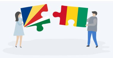 Seychellois ve Gine bayrakları ile iki bulmaca parçaları tutan çift. Seyşeller ve Gine ulusal sembolleri birlikte.