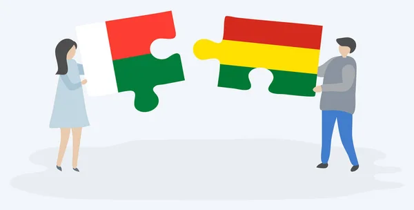 一对夫妇拿着两块拼图 上面挂着马达加斯加和玻利维亚国旗 马达加斯加和玻利维亚国家符号在一起 — 图库矢量图片