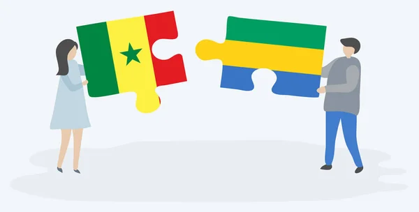 Casal Segurando Duas Peças Quebra Cabeças Com Bandeiras Senegalesas Gabonesas — Vetor de Stock