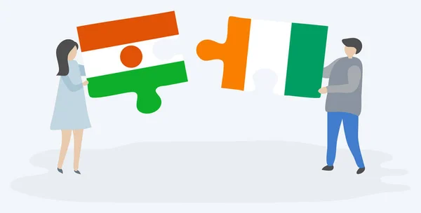 一对夫妇拿着两块拼图 上面挂着尼日尔和科特迪瓦国旗 尼日尔和象牙海岸国家符号在一起 — 图库矢量图片