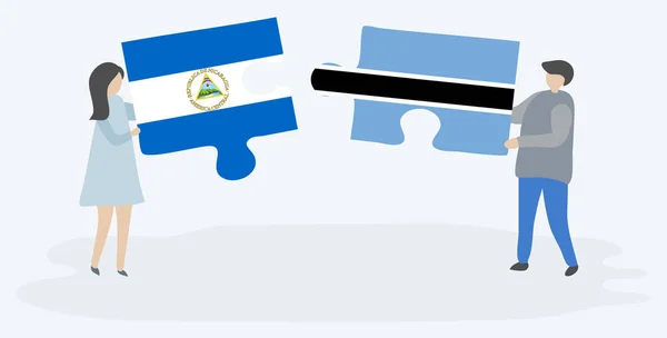Para Trzyma Dwa Kawałki Puzzli Nikaraguan Flagi Motswana Nikaragua Botswana — Wektor stockowy