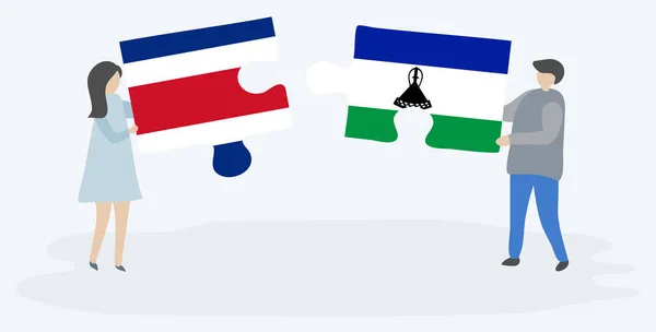 コスタリカとバソトの旗を持つ2つのパズルピースを保持しているカップル コスタリカとレソトの国のシンボル — ストックベクタ