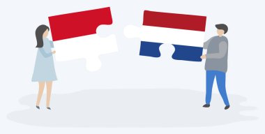 Monegasque ve Hollanda bayrakları ile iki bulmaca parçaları tutan çift. Monako ve Hollanda ulusal sembolleri birlikte.
