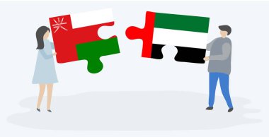 Umman ve Emirian bayrakları ile iki bulmaca parçaları tutan çift. Umman ve Birleşik Arap Emirlikleri ulusal sembolleri birlikte.