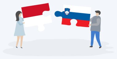 Monegasque ve Sloven bayrakları ile iki bulmaca parçaları tutan çift. Monako ve Slovenya ulusal sembolleri bir arada.