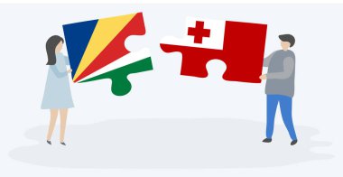 Seychellois ve Tongan bayrakları ile iki bulmaca parçaları tutan çift. Seyşeller ve Tonga ulusal sembolleri birlikte.