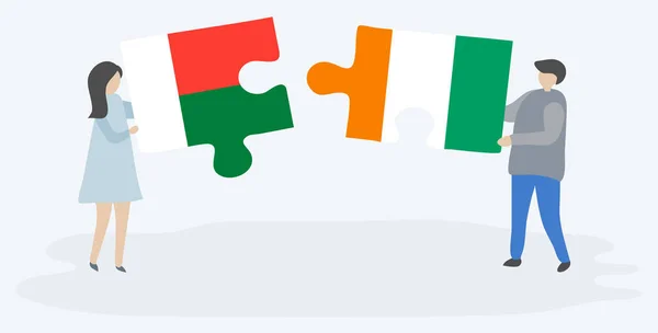 Paar Houden Twee Puzzels Stukken Met Malagasi Ivoriaanse Vlaggen Nationale — Stockvector