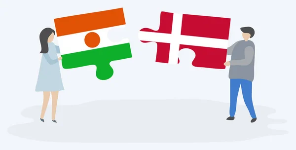 一对夫妇拿着两块拼图 上面挂着尼日尔和丹麦国旗 尼日尔和丹麦国家符号在一起 — 图库矢量图片