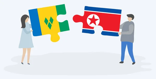 Пара Держащая Две Головоломки Винчентианскими Северокорейскими Флагами Сент Винсент Гренадины — стоковый вектор