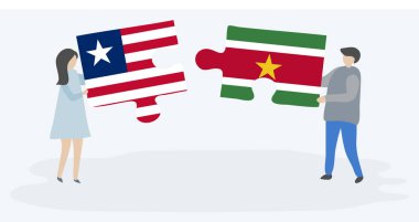 Liberya ve Surinam bayrakları ile iki bulmaca parçaları tutan çift. Liberya ve Surinam ulusal sembolleri birlikte.
