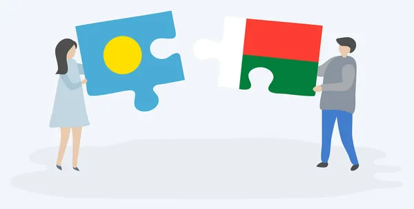 Para Trzyma Dwa Kawałki Puzzli Palauan Madagaskaru Flagi Palau Madagaskar — Wektor stockowy