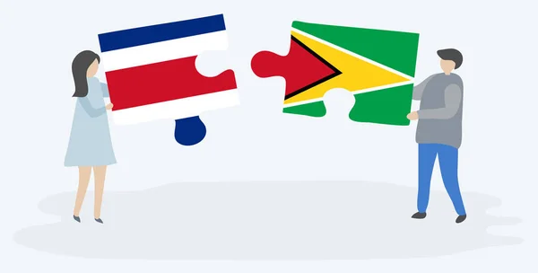 コスタリカとガイアナの旗を持つ2つのパズルピースを保持しているカップル コスタリカとガイアナの国のシンボル — ストックベクタ