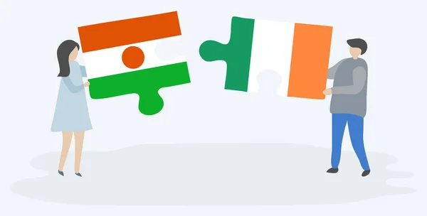 Couple Tenant Deux Pièces Puzzles Avec Des Drapeaux Nigériens Irlandais — Image vectorielle