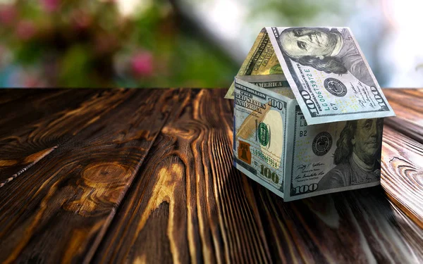 Doları Lirası ahşap masa üstünde ev yapılmış